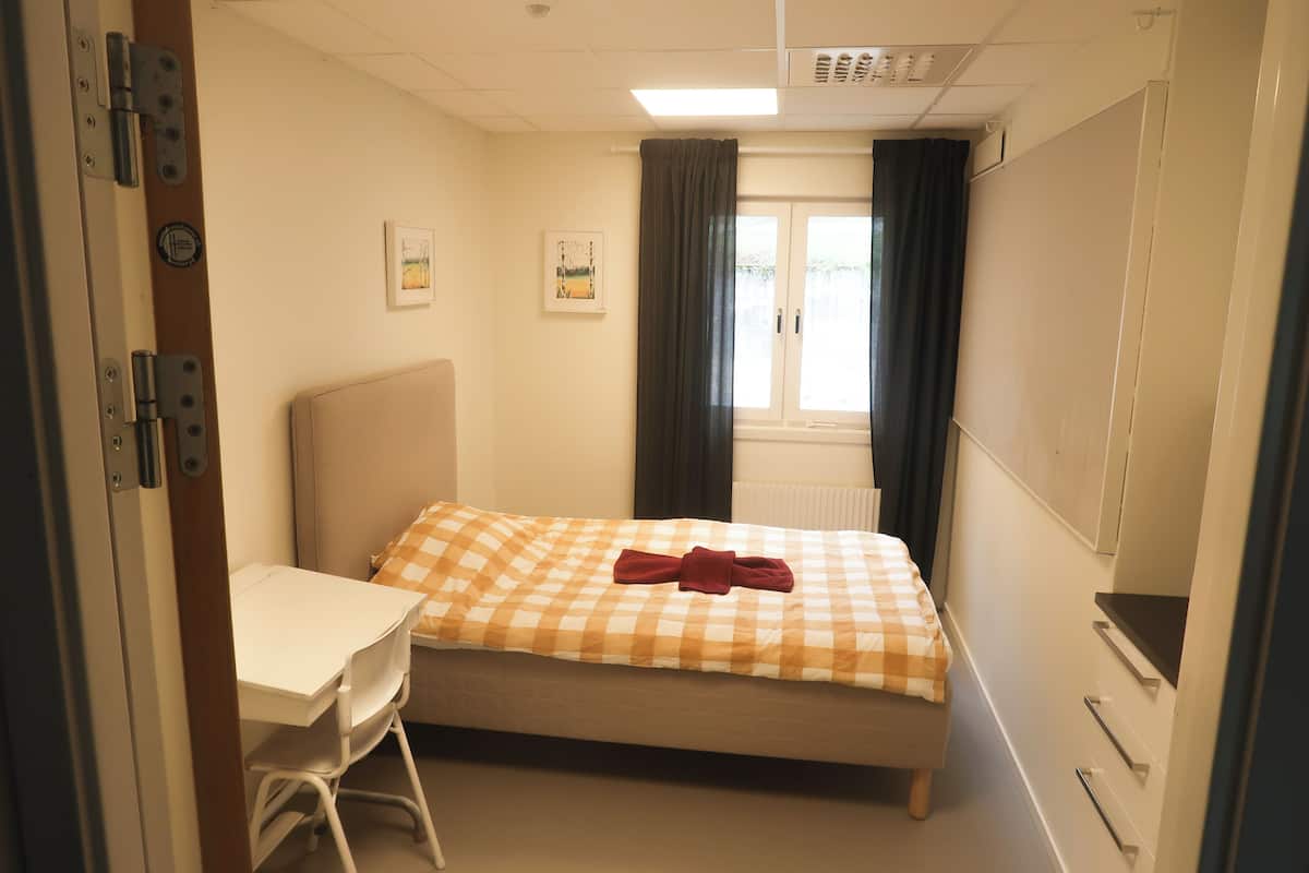 Une chambre d’hôtel avec un lit, une petite table et une chaise.