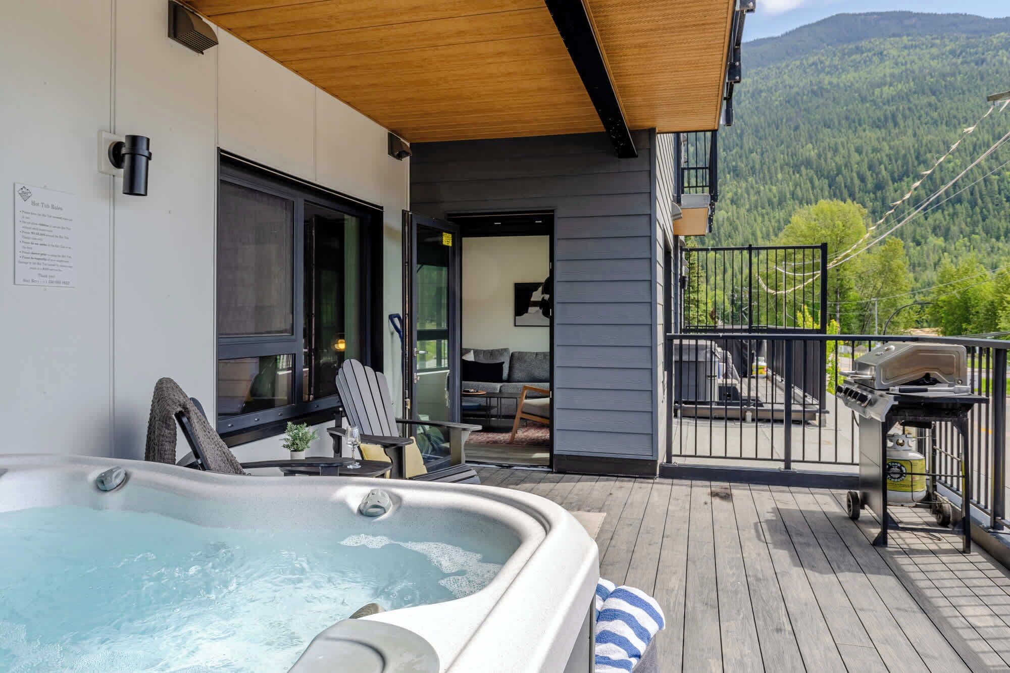 Un jacuzzi en una terraza de madera con vista a las montañas.