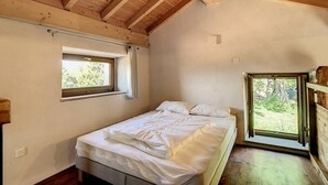 A bedroom with a wooden ceiling, a single bed, a window, and a view of the outdoors. - Location Saisonnière Atypique à Porticcio (PORTICCIO)