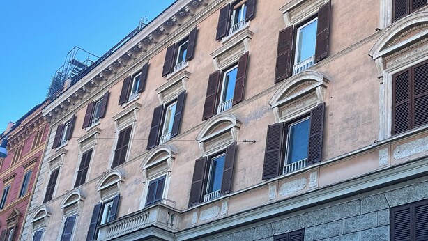 A multi-story building with classical architecture, featuring arched windows and stone facades. - 1 bedroom apartment in rome (Roma)