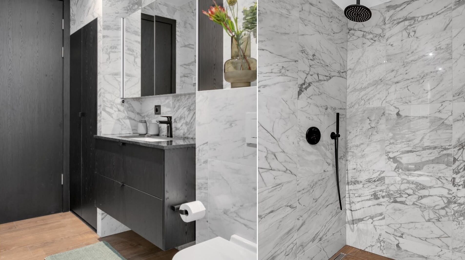 Un bagno moderno con pareti doccia in marmo, un mobile lavabo in legno scuro e uno specchio grande sopra il lavandino.