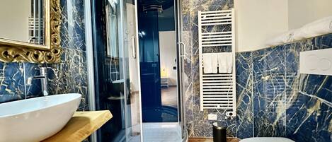 Une salle de bain avec une douche à parois de verre, un lavabo blanc et des toilettes.