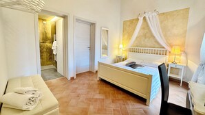 Une chambre à coucher avec un lit, une chaise, une table de chevet et un miroir.