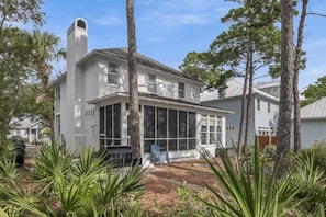 Une maison blanche dotée d’une grande véranda, d’une cheminée et d’un patio abrité.
