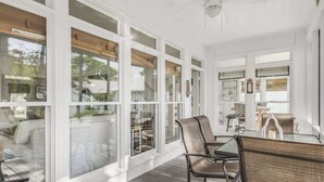 A sunroom with large windows, a glass table, wicker chairs, and a ceiling fan. - 4 Bikes - Walk to beach, 2 Pools - `Gulf Station` (Santa Rosa Beach)