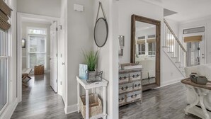 A hallway with a white door, a wicker basket, a plant, and a mirror. - 4 Bikes - Walk to beach, 2 Pools - `Gulf Station` (Santa Rosa Beach)
