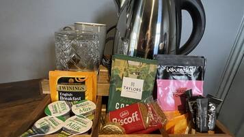 A wooden tray with breakfast items including Twinings English Breakfast, Lakeland Milk, Taylors of Harrogate, Lotus Biscuits, and Wheatley's Specially Sourced Hot Chocolate.