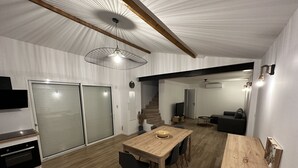 Une cuisine moderne avec une table à manger en bois, des chaises et un four encastré.