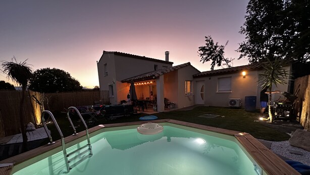 Un jardin avec une piscine, un espace patio et une maison.