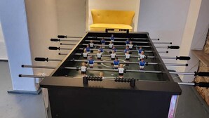 Ein Kicker mit Schublade darunter, platziert auf einem gemusterten Teppich.