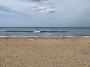 Una playa con cielo despejado y mar tranquilo.