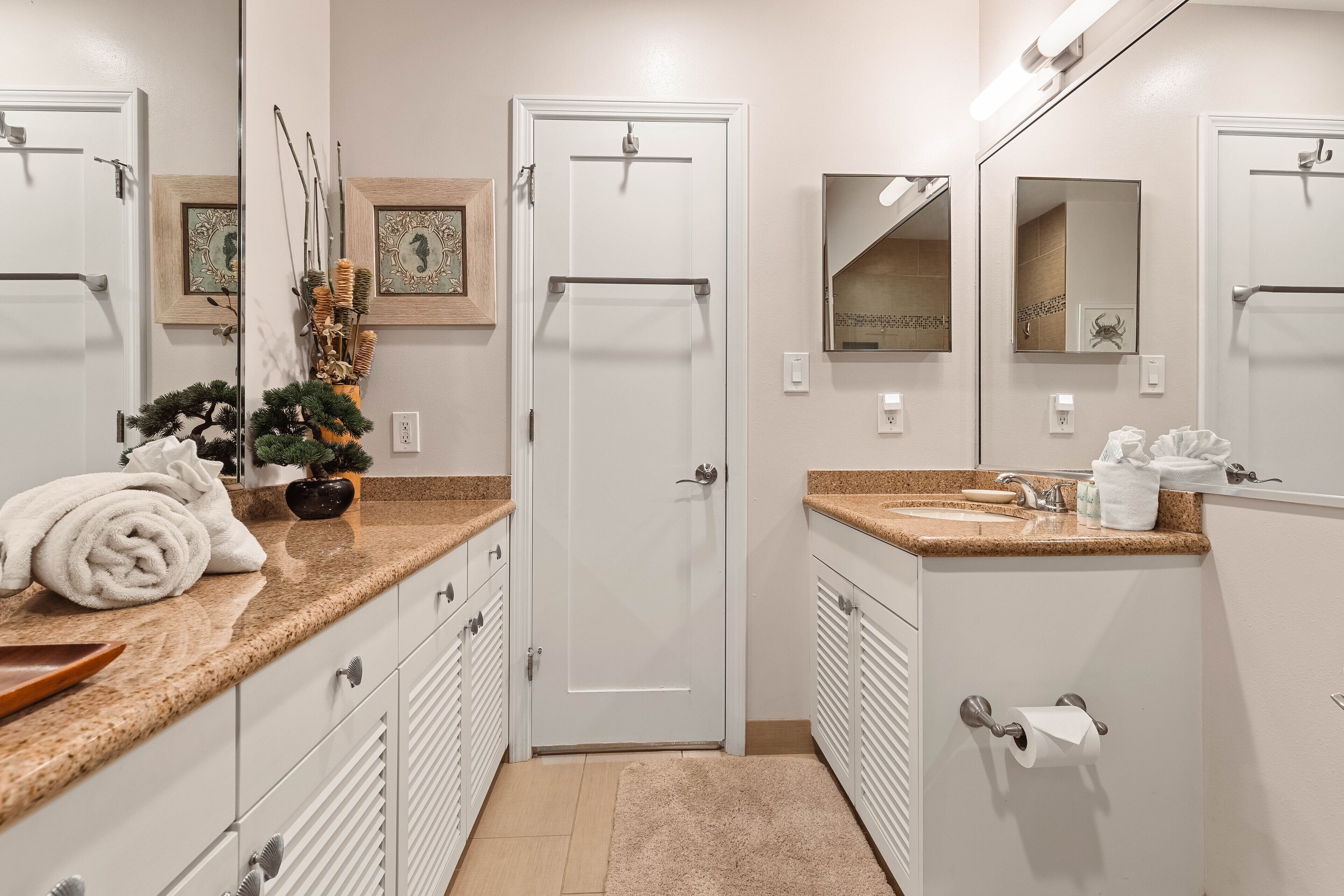 Une salle de bain avec une porte blanche, un lavabo doté d’un plan-vasque beige et un miroir au-dessus du lavabo.