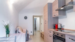 A compact kitchen with a built-in oven, a coffee maker, and a kettle on the countertop. - Corte d Appello Rooms (Turin)