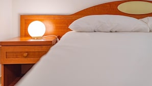A neatly made bed with white linens and a wooden headboard. - Corte d Appello Rooms (Turin)