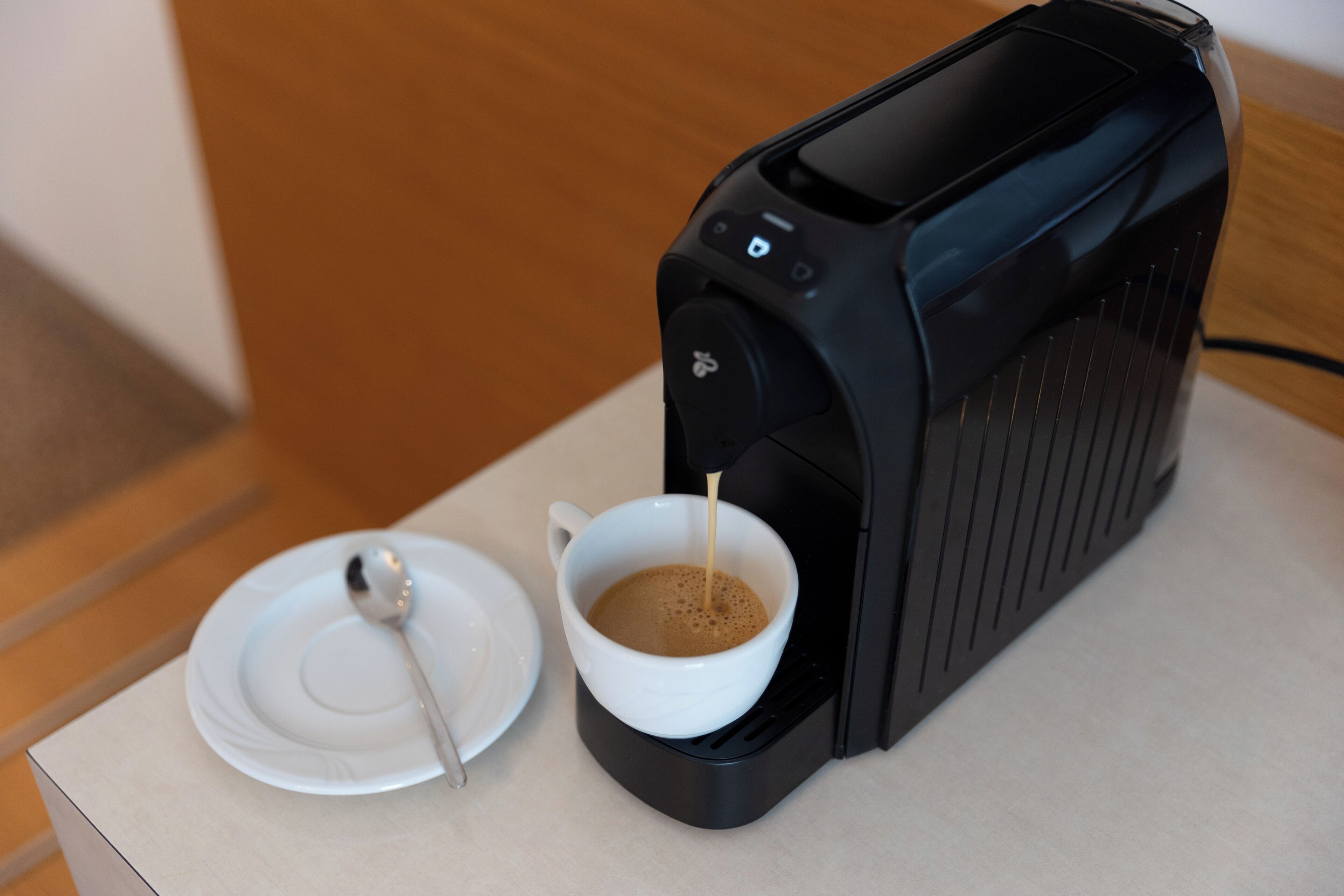 A coffee machine dispensing coffee into a cup.