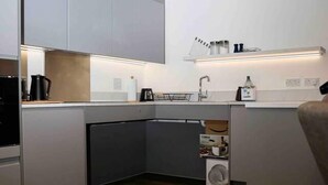 Een moderne keuken met grijze kastjes, een ingebouwde oven en een vaatwasser.