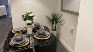 Een eettafel gedekt met borden, kommen en een bloevas.