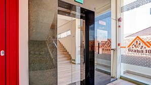 Entrada de un hotel con puerta de cristal, una escalera y un letrero que dice 'Granada Hotel Guesthouse'.