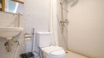 Un baño con inodoro, lavabo y ducha.