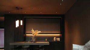 A modern interior with a dining area, a sofa, and a kitchen. - Signature by Vík Apartments (Vik I Myrdal)