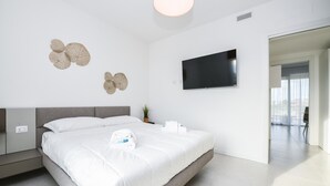 Ein modernes Hotelzimmer mit einem Bett, einem Flachbildfernseher und Wanddekorationen.