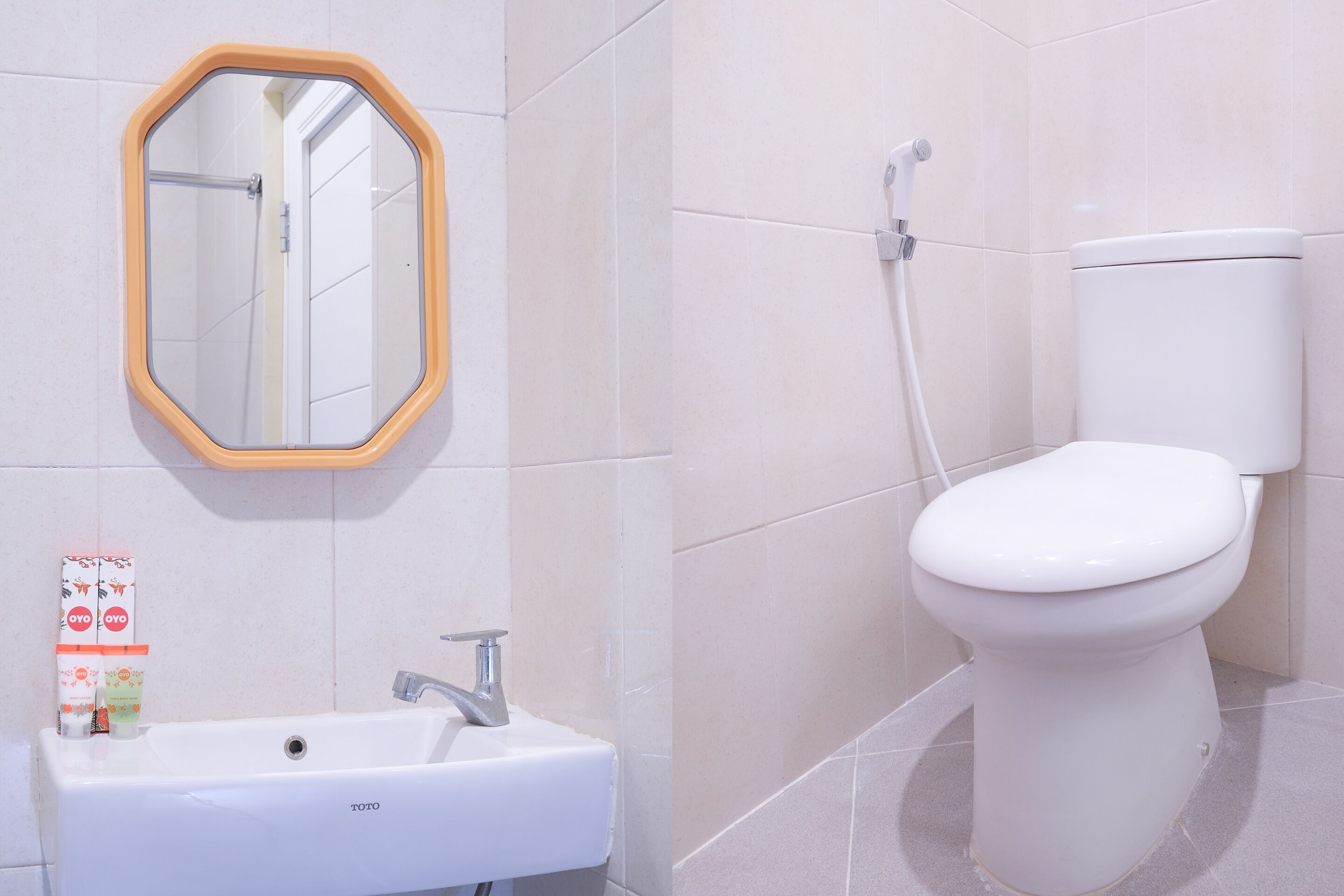 A bathroom with a white sink, a mirror with a wooden frame, and a toilet.