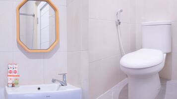 A bathroom with a white sink, a mirror with a wooden frame, and a toilet.