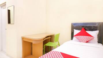 A hotel room with a bed, a desk, and a chair.