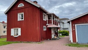 Un bâtiment en bois rouge avec un porche et un garage.
