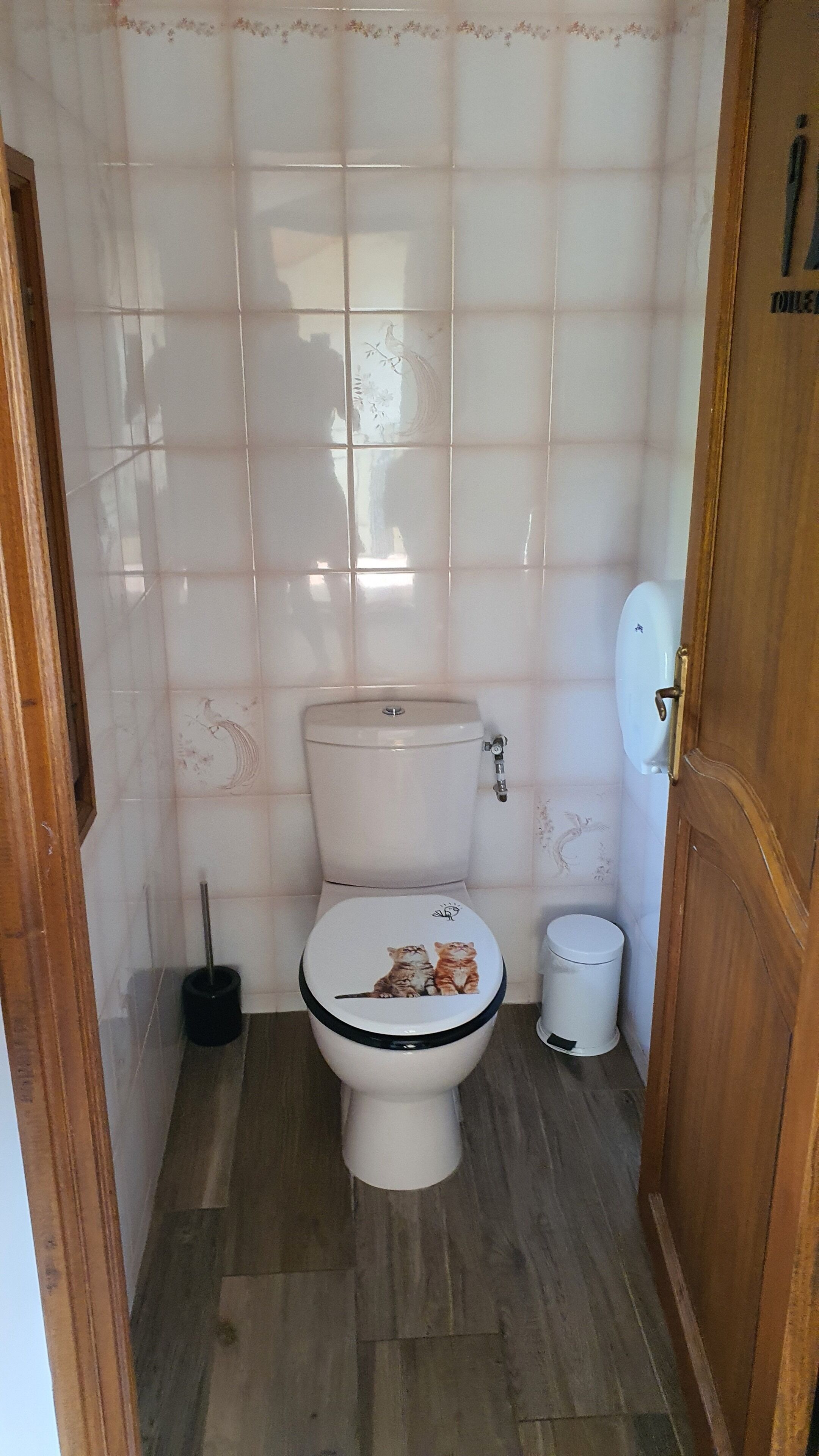 A small bathroom with a toilet, a bidet, and a trash bin.