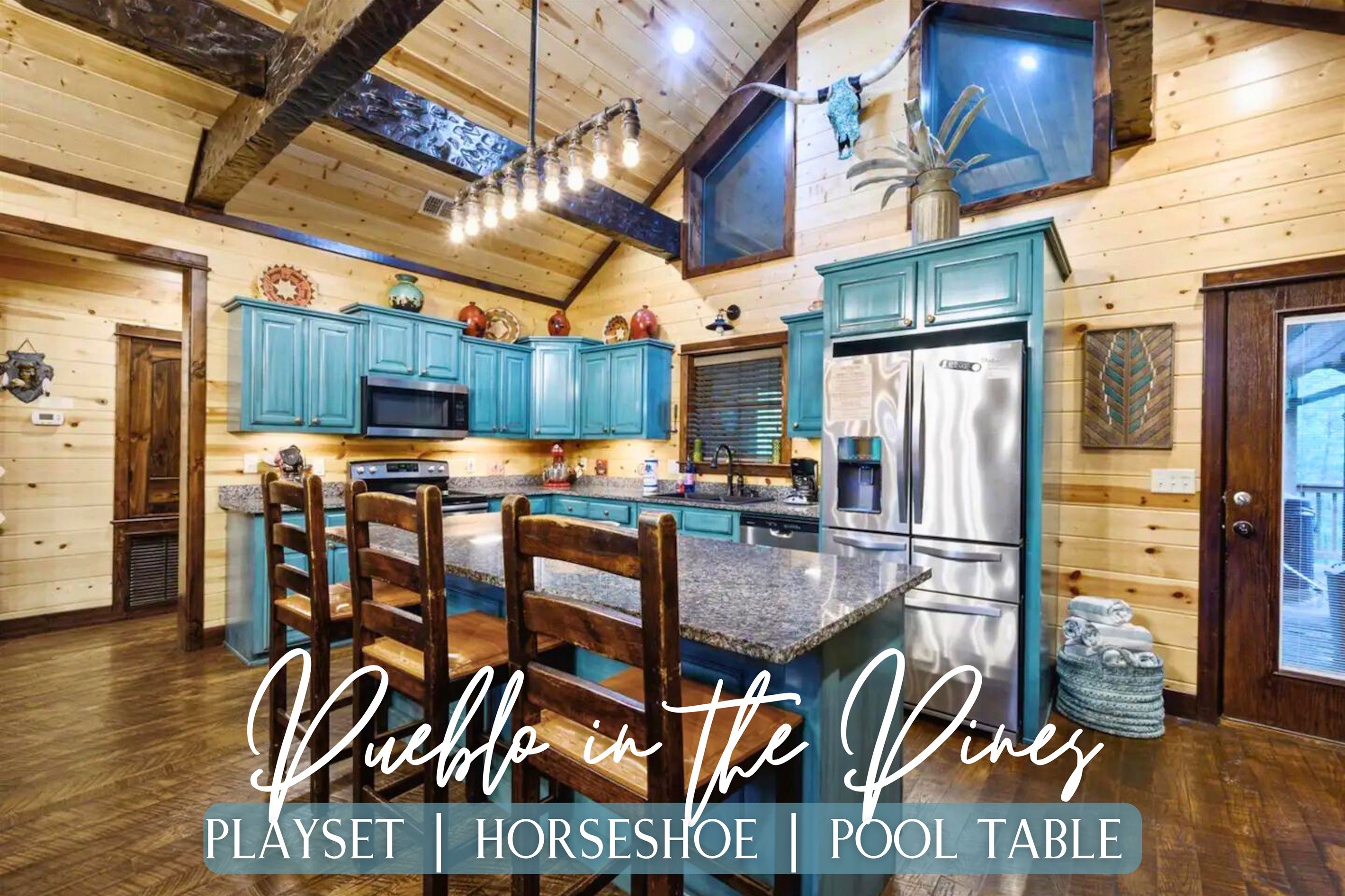 A rustic kitchen with wooden cabinets, a stainless steel refrigerator, and a large island with a pool table.