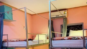 A dormitory room with bunk beds, a wardrobe, and a window with curtains. - Luang Prabang Hostel (Luang Prabang)