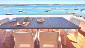 Tavolo apparecchiato per due con vista sul mare e sulle barche.