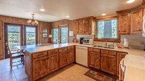 A spacious kitchen with wooden cabinets, a large island, and a dishwasher. - Near Lake Hatcher and walk to San Juan Forest, Quiet Area. (Pagosa Springs)