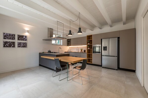 A modern kitchen with a central island, pendant lighting, and built-in appliances.