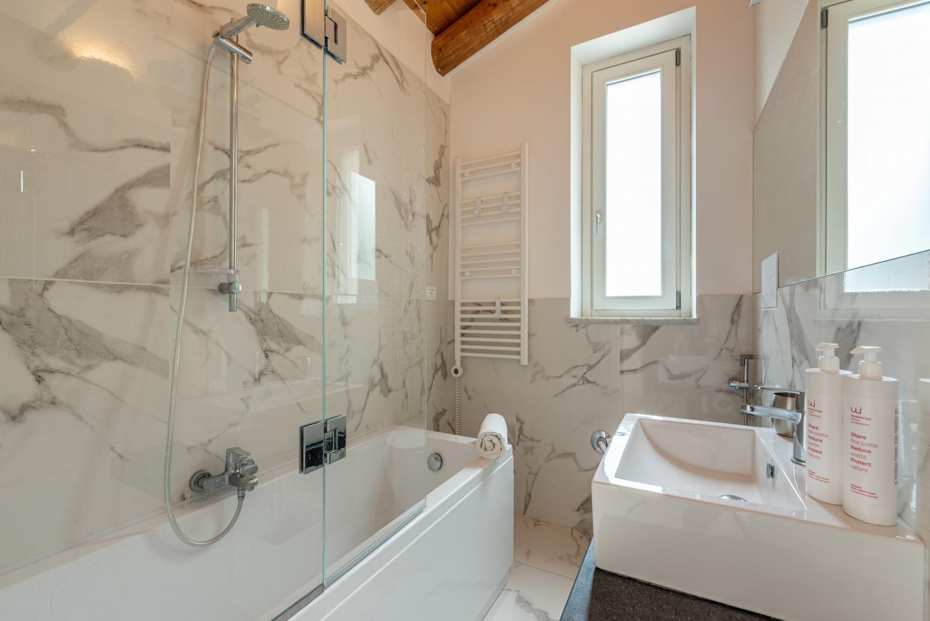 A modern bathroom with a glass-enclosed shower, a freestanding bathtub, and a vanity with a sink and mirror.