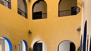 A pool area with a tiled floor, archways, and a door with decorative elements. - Riad La Luna (Merzouga)