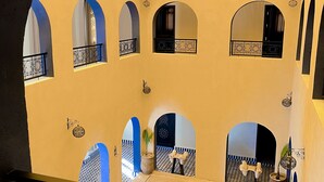 A courtyard with multiple arches and a central seating area. - Riad La Luna (Merzouga)