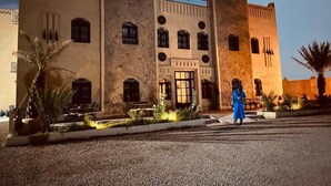 A large, historic building with multiple arches and a central entrance. - Riad La Luna (Merzouga)