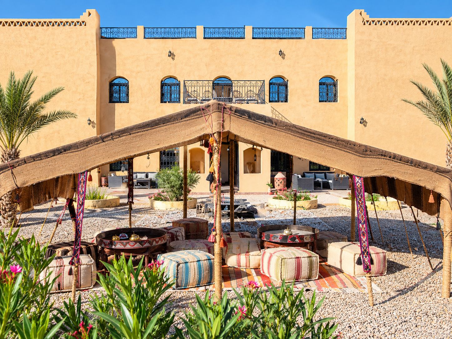 A courtyard with a central seating area, surrounded by a building with multiple windows and balconies.
