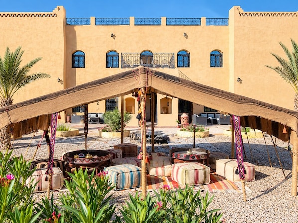 Un patio con una zona de estar central, rodeado por un edificio con múltiples ventanas y balcones.