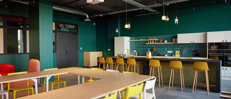 Una cocina moderna con una isla central, sillas amarillas y una mesa de madera.