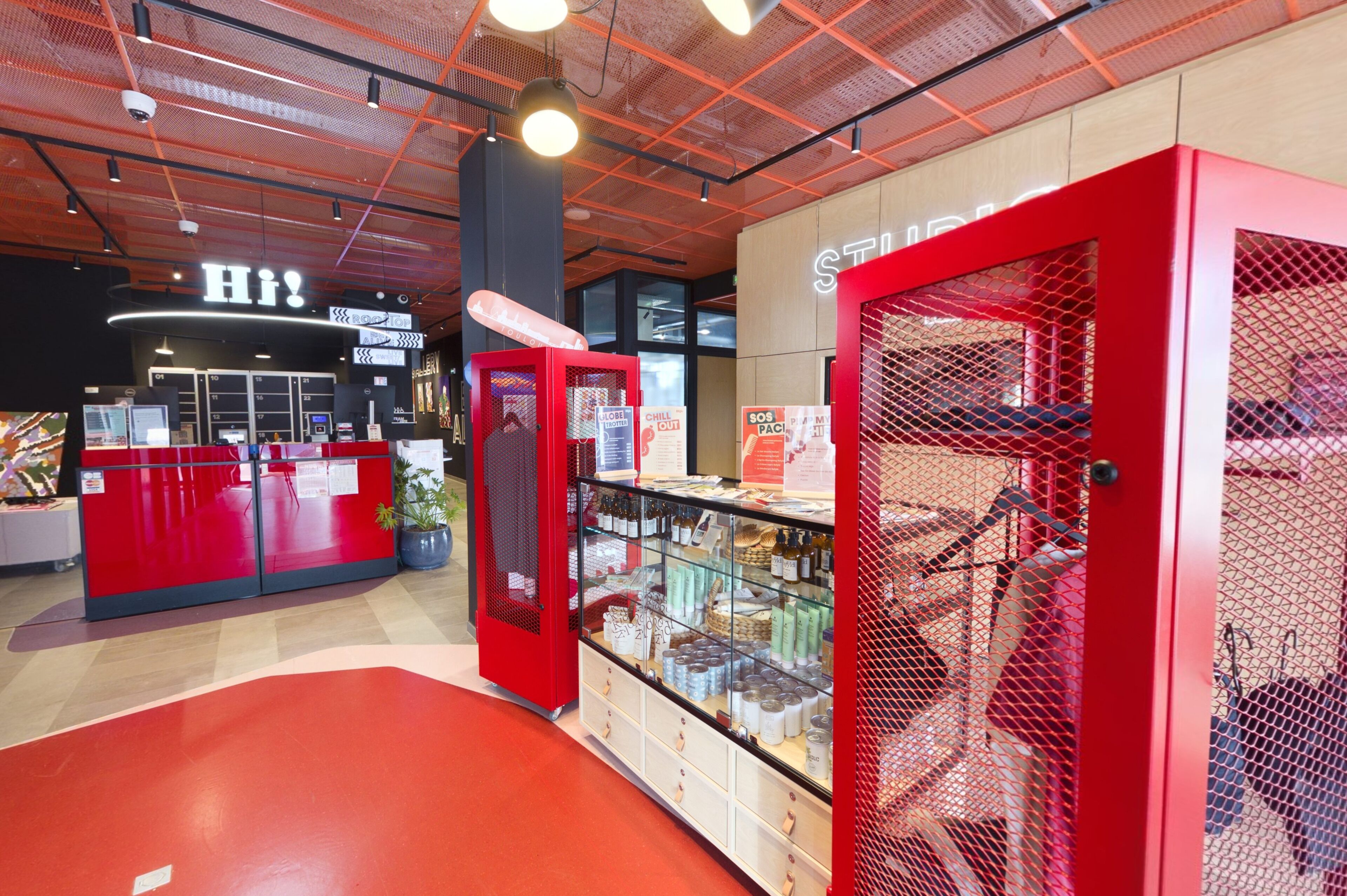 A modern interior with a reception desk, a red display case, and a sign reading 'SOS PACE'.