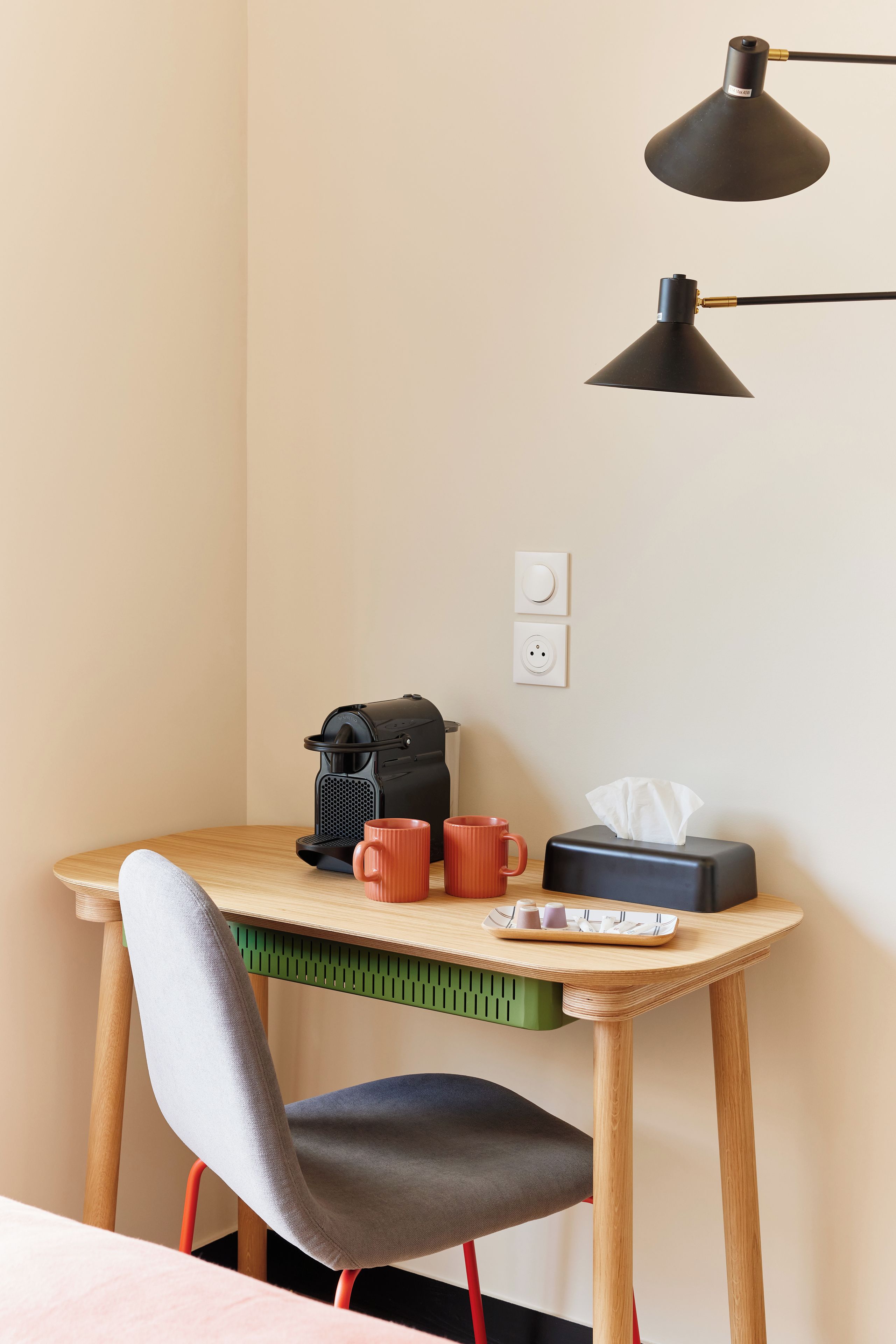 Una mesita con una cafetera, una caja de pañuelos y dos tazas.