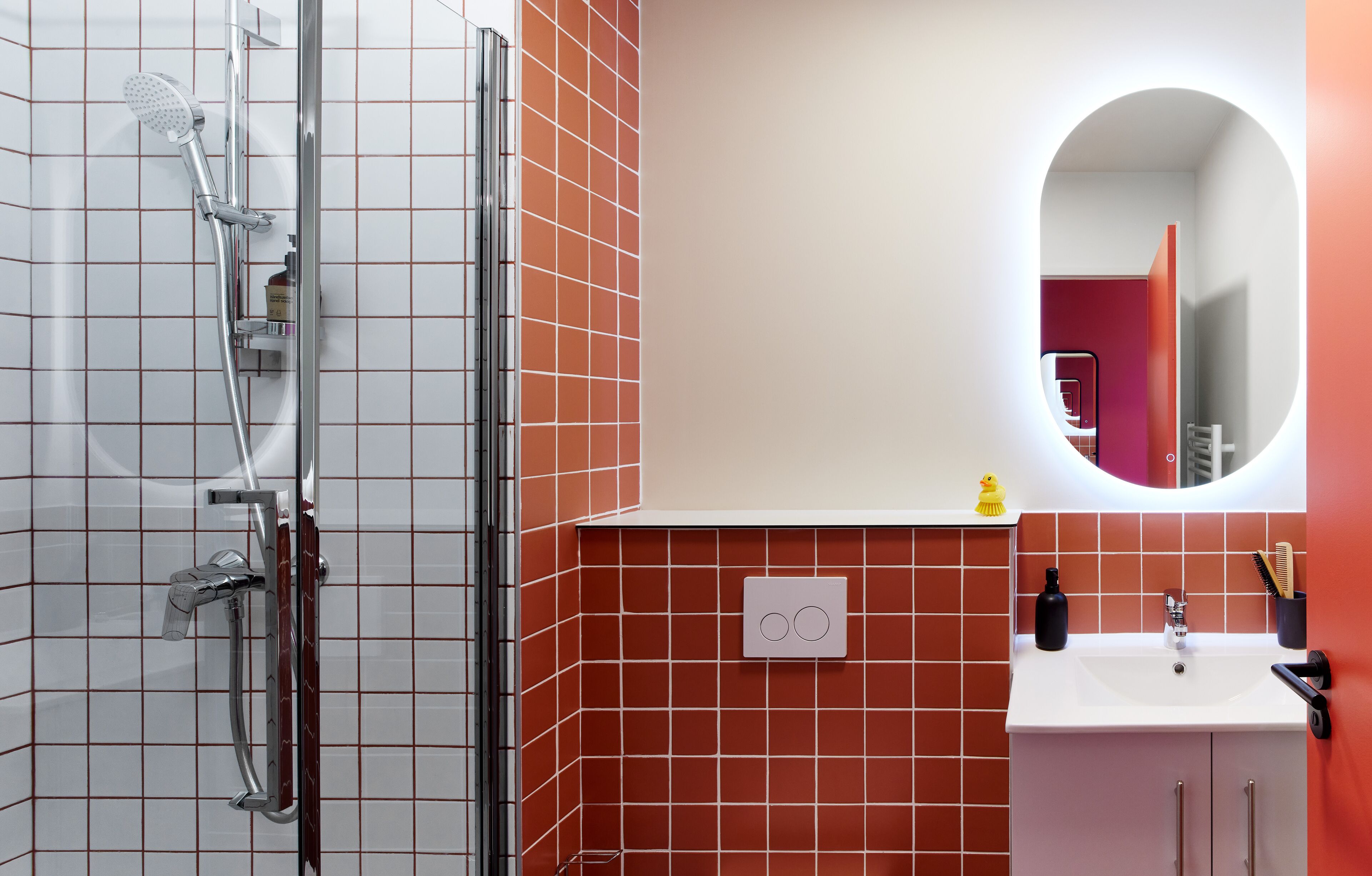 Un baño con ducha, lavamanos y espejo.
