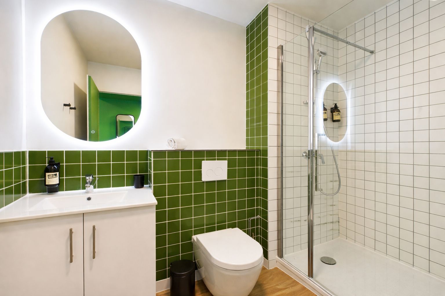 Un baño con ducha, inodoro, lavamanos y espejo.