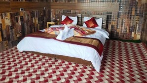 Un lit avec un sol à carreaux rouges et blancs, une tête de lit en bois et une couvre-lit à motifs.