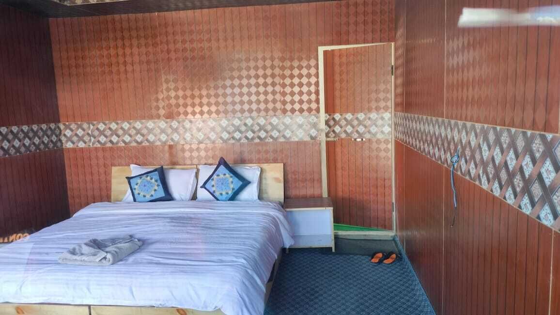 Ein Zimmer mit Bett, Nachttisch und Tür.