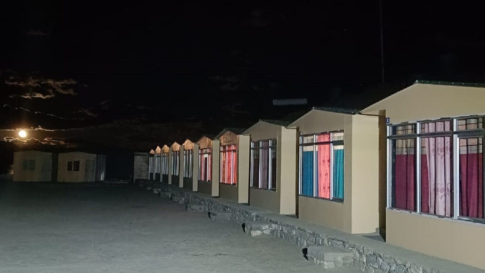 A row of small, single-story buildings with windows, likely a hotel or resort.