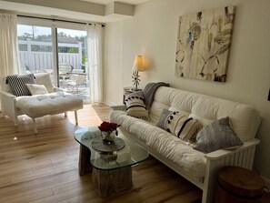 Relax in this stylish living room with a sofa, armchair, and glass coffee table.